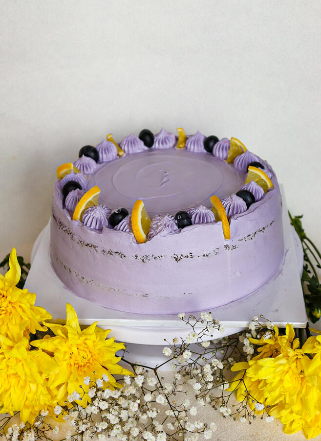 Lemon & BlueberryLemon Cake, dotted with Blueberries, filled with Lemon curd (or Blueberry jam) covered in Blueberry cream, topped with lemon Zest and blueberries.